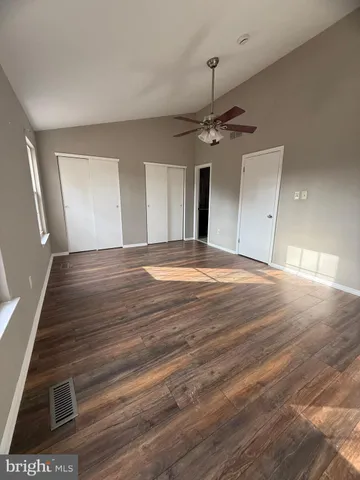 a view of an empty room with window and a kitchen