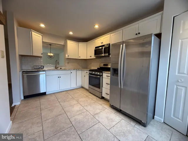 a kitchen with stainless steel appliances granite countertop a refrigerator sink and cabinets