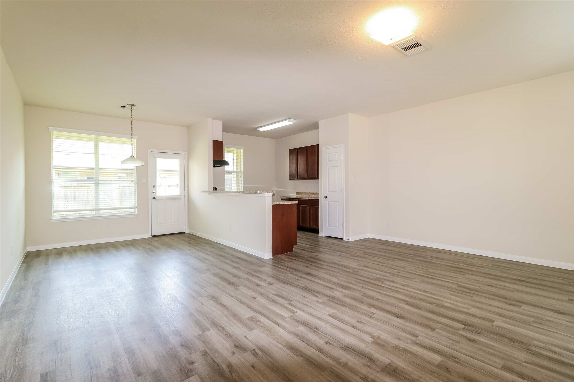 12307 Roy Mix Bohn Lane Houston, TX 77044 - Photo 8 of 17 an empty room with wooden floor and windows