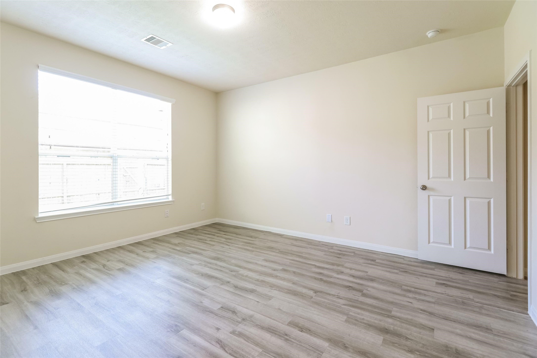 12307 Roy Mix Bohn Lane Houston, TX 77044 - Photo 9 of 17 an empty room with wooden floor and windows