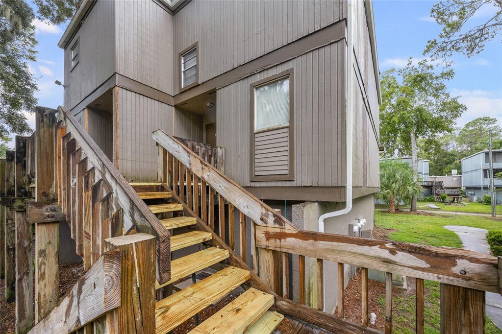 713 Southwest 75th Street, Unit 201 Gainesville, FL 32607 - Photo 1 of 1 a view of a house with wooden stairs and a floor to ceiling window