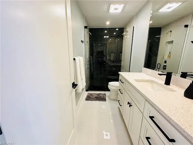 a bathroom with a double vanity sink mirror and shower