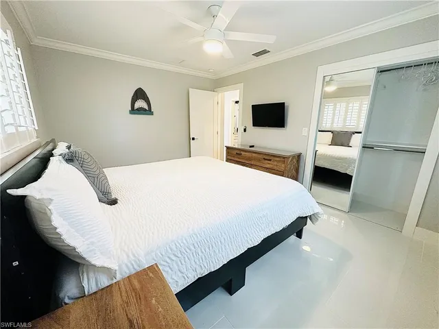 a bedroom with a large bed flat screen tv and a window