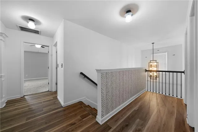 a view of a hallway with wooden floor and staircase