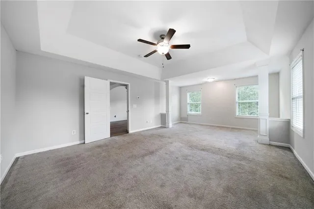a view of a big room with windows and chandelier fan