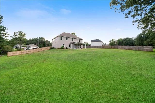 a view of a big yard with potted plants and large trees