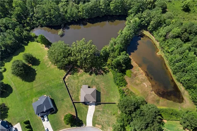 an aerial view of lake residential house with outdoor space and trees around