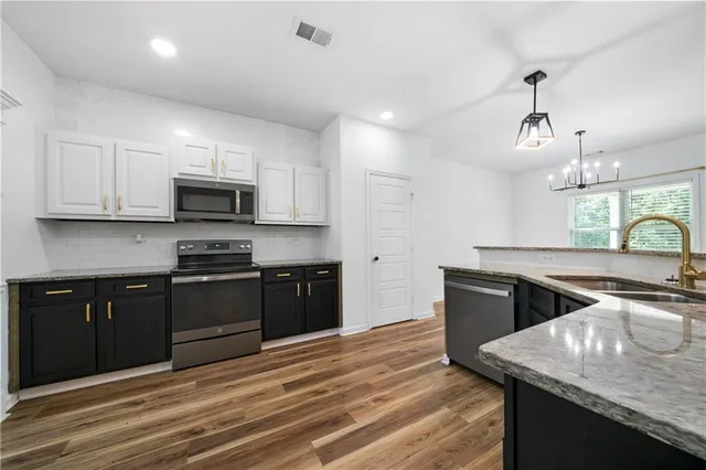 a kitchen with stainless steel appliances granite countertop a sink stove and microwave
