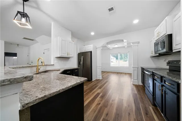 a kitchen with stainless steel appliances granite countertop a sink stove and refrigerator