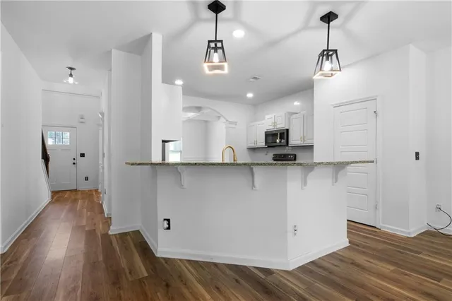 a view of a kitchen with wooden floor and a sink