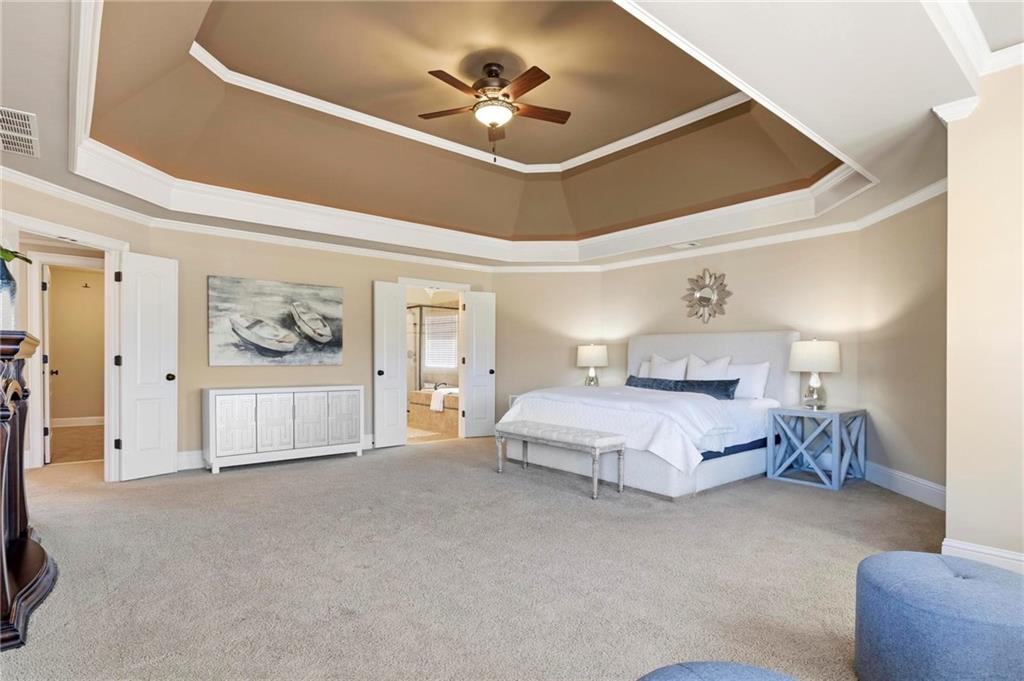 2602 Alcovy Club Drive Dacula, GA 30019 - Photo 17 of 44 a spacious bedroom with a bed and a chandelier