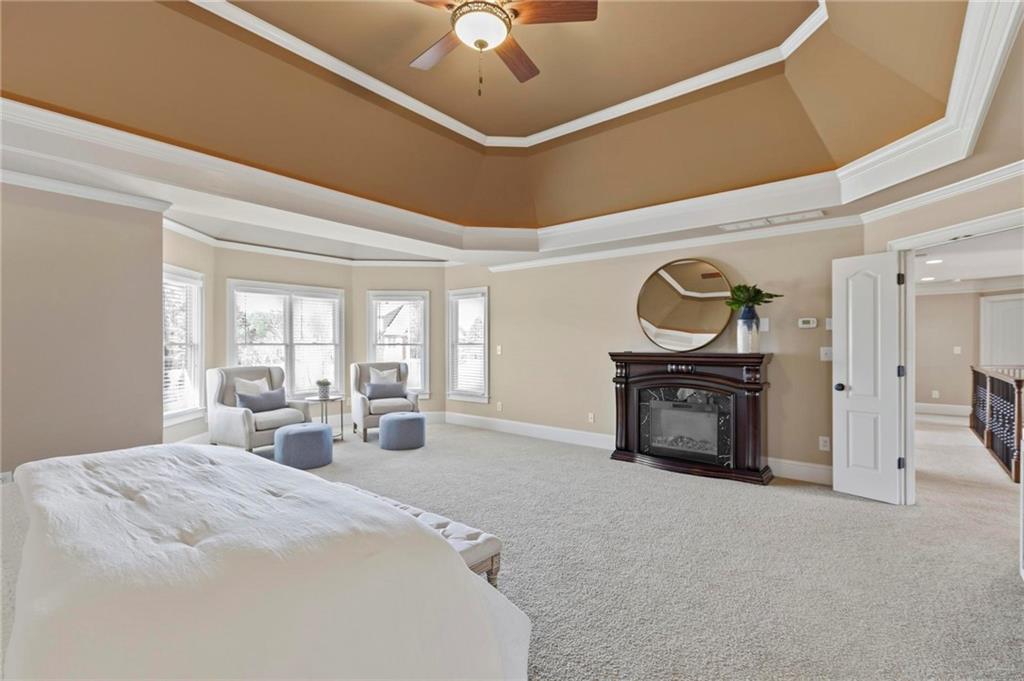 2602 Alcovy Club Drive Dacula, GA 30019 - Photo 18 of 44 a spacious bedroom with a bed and a chandelier