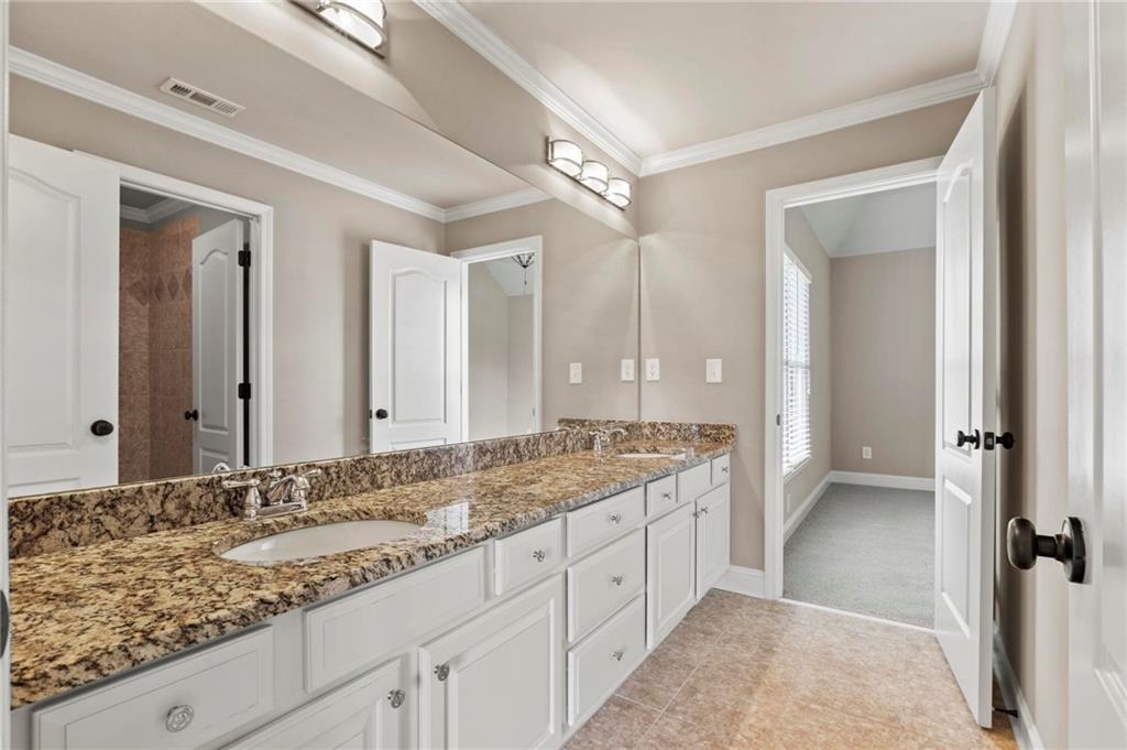 2602 Alcovy Club Drive Dacula, GA 30019 - Photo 25 of 44 a bathroom with a granite countertop sink and a mirror