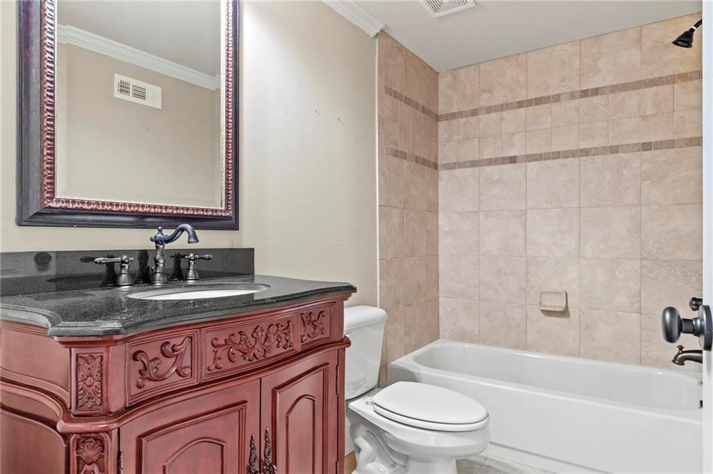 2602 Alcovy Club Drive Dacula, GA 30019 - Photo 29 of 44 a bathroom with a granite countertop sink a toilet mirror and bathtub