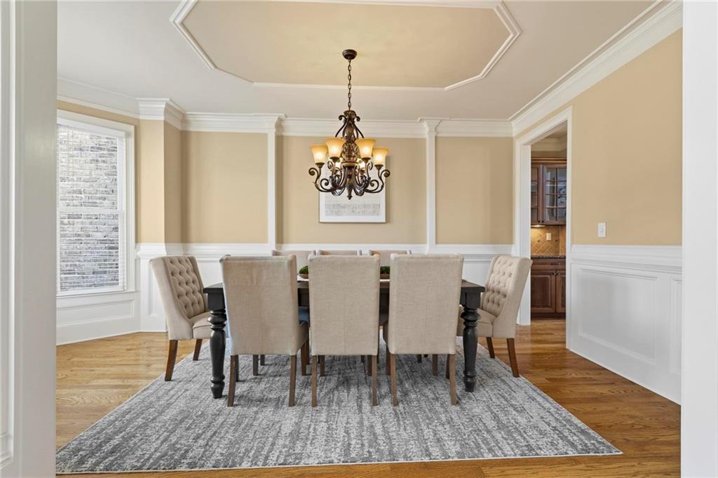 2602 Alcovy Club Drive Dacula, GA 30019 - Photo 7 of 44 a dining room with furniture wooden floor a rug and a chandelier