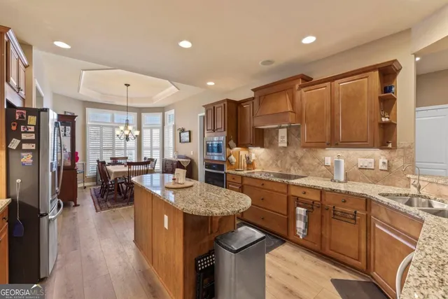 a dining room with furniture a chandelier and wooden floor