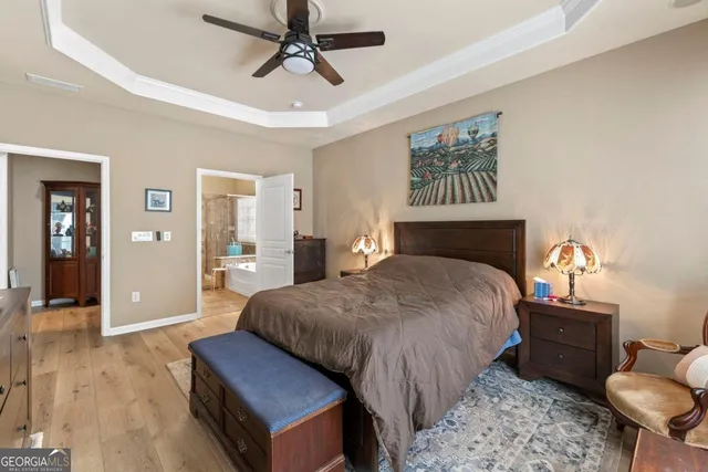 a bedroom with a large bed and a chandelier