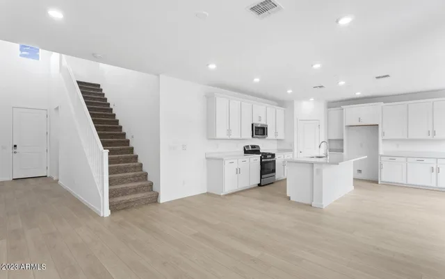 a kitchen with white cabinets and white appliances
