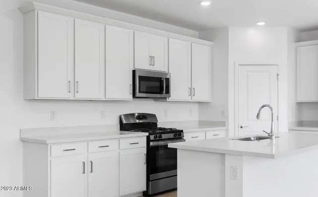 a kitchen with white cabinets and stainless steel appliances