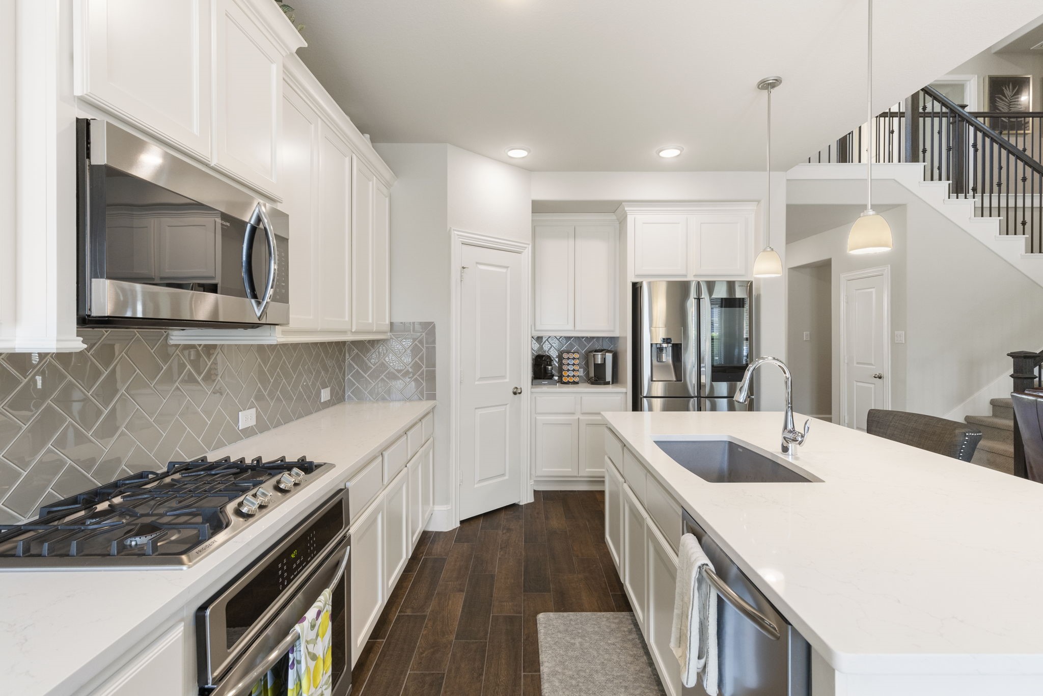 1030 Bat Hawk Court Conroe, TX 77385 - Photo 17 of 47 a kitchen with a sink stove and microwave