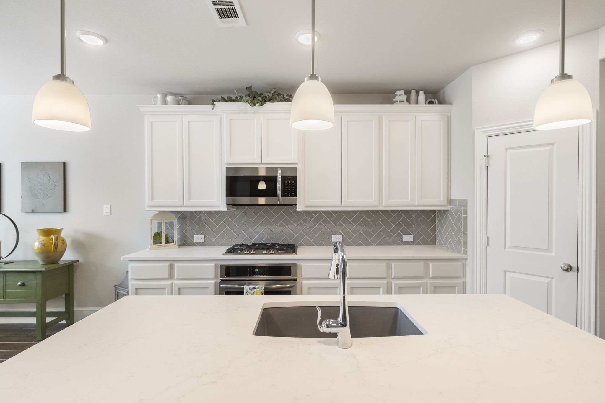 1030 Bat Hawk Court Conroe, TX 77385 - Photo 18 of 47 a kitchen with stainless steel appliances a stove a sink and white cabinets
