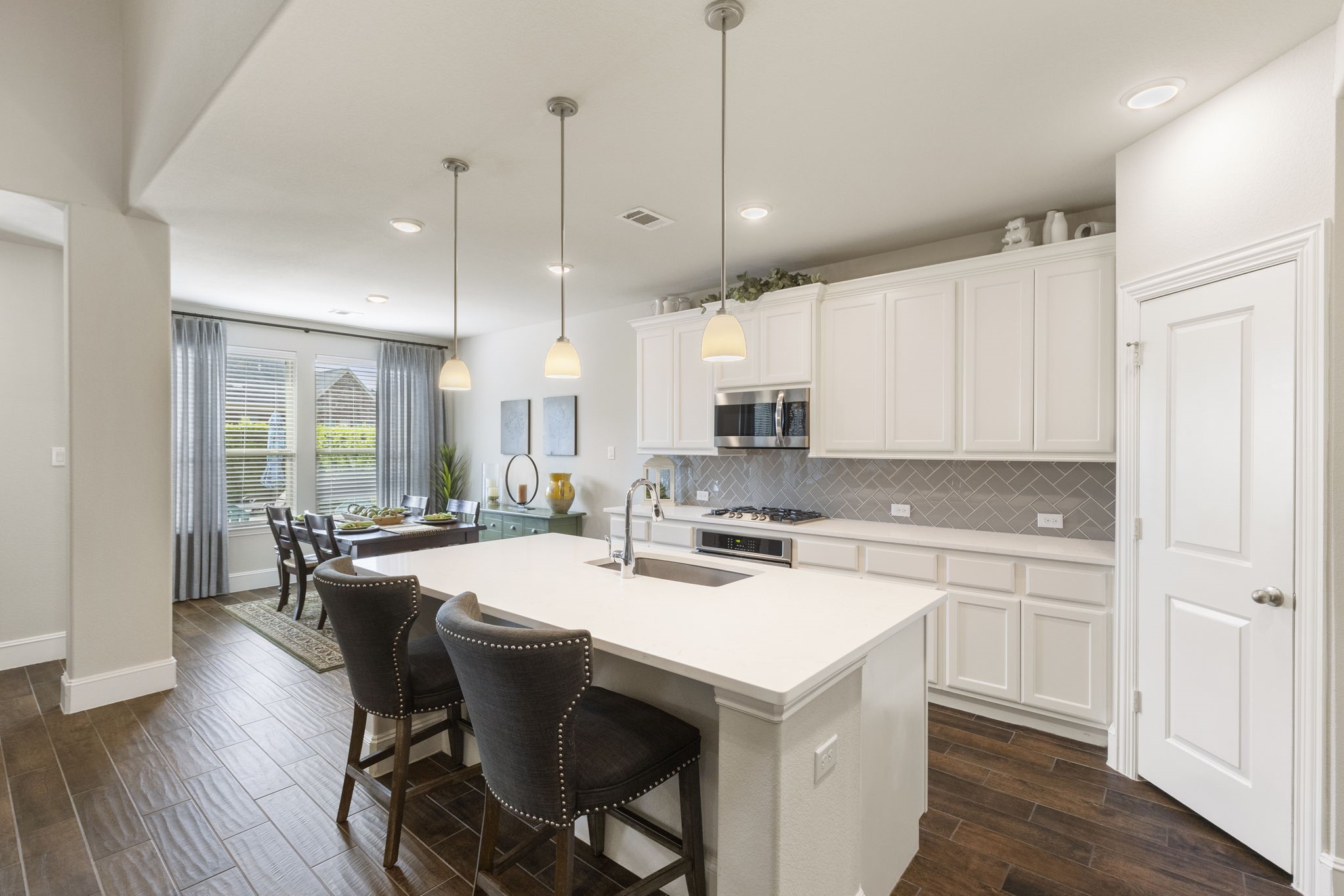 1030 Bat Hawk Court Conroe, TX 77385 - Photo 3 of 47 a kitchen with a stove a sink a dining table and chairs