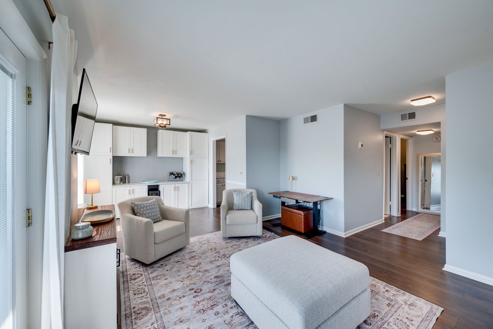 a living room with furniture and a wooden floor