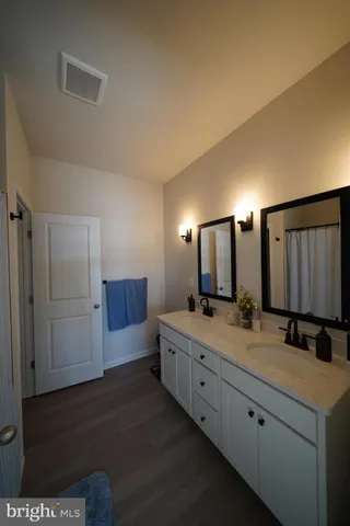 a bedroom with a bed and a flat tv screen on dresser