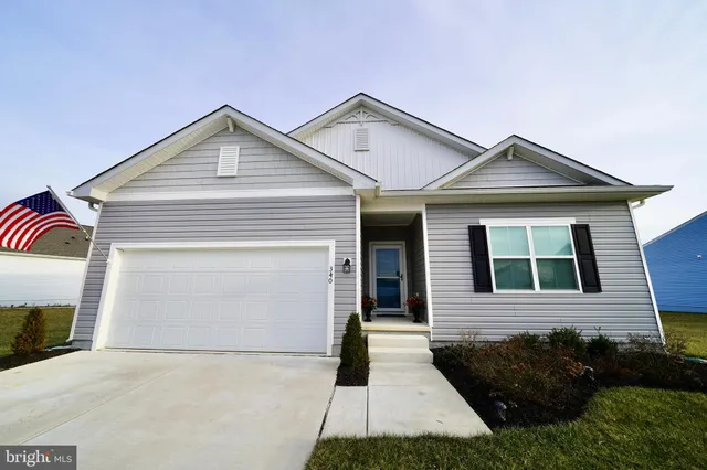 a kitchen with stainless steel appliances kitchen island granite countertop a stove a refrigerator a kitchen island a dining table and chairs with wooden floor