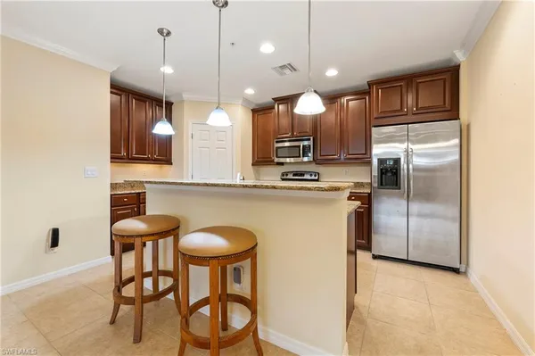 a kitchen with a table chairs refrigerator and microwave