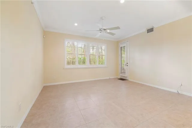 an empty room with windows and chandelier fan