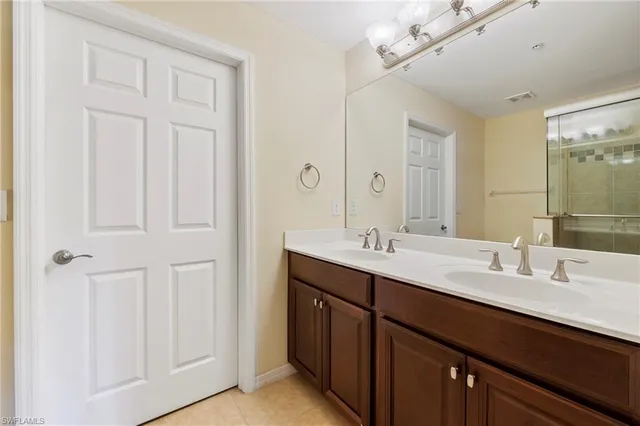 a bathroom with double vanity sink a vanity and a mirror