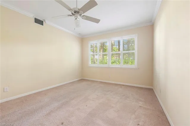 an empty room with a window and a fan