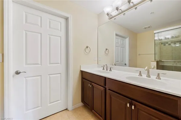 a bathroom with double vanity sink a vanity and a mirror