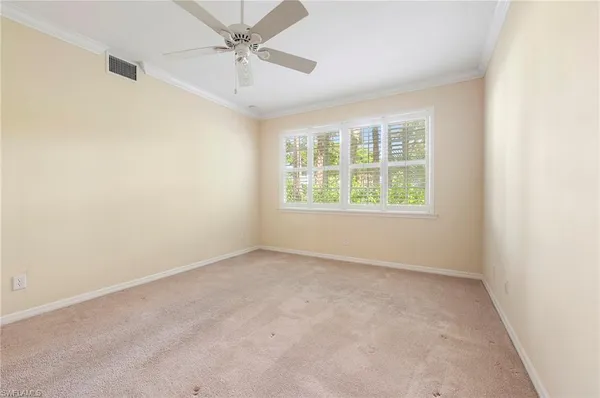 an empty room with a window and a fan