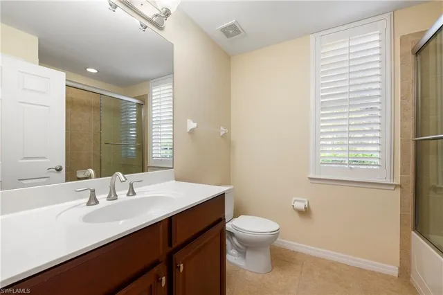 a bathroom with a sink a toilet and a large mirror