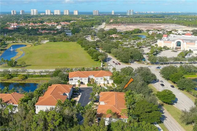 an aerial view of residential houses with outdoor space and lake view