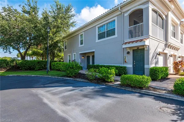 a front view of a house with garden and trees