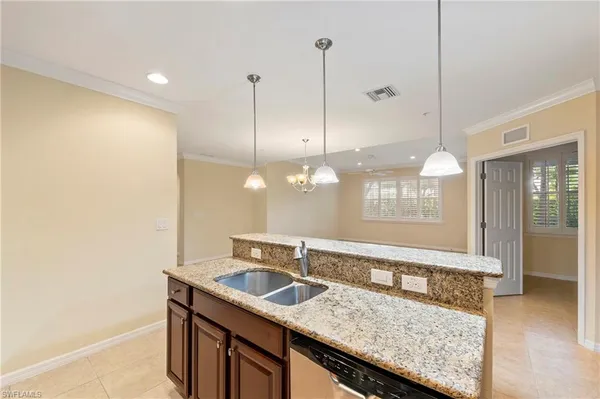 a kitchen with a sink a counter space and wooden floor