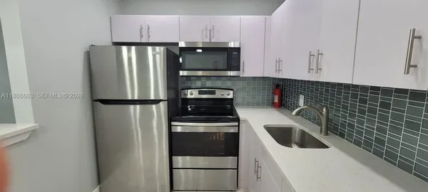 a kitchen with stainless steel appliances a refrigerator sink and cabinets