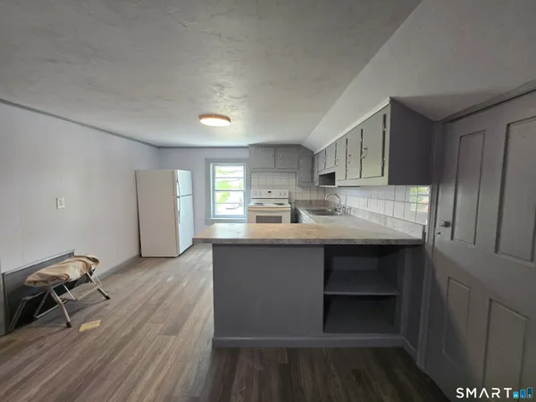 a kitchen with granite countertop a sink cabinets and wooden floor