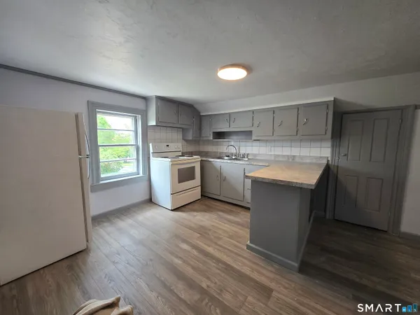 a kitchen with a white stove top oven sink and cabinets