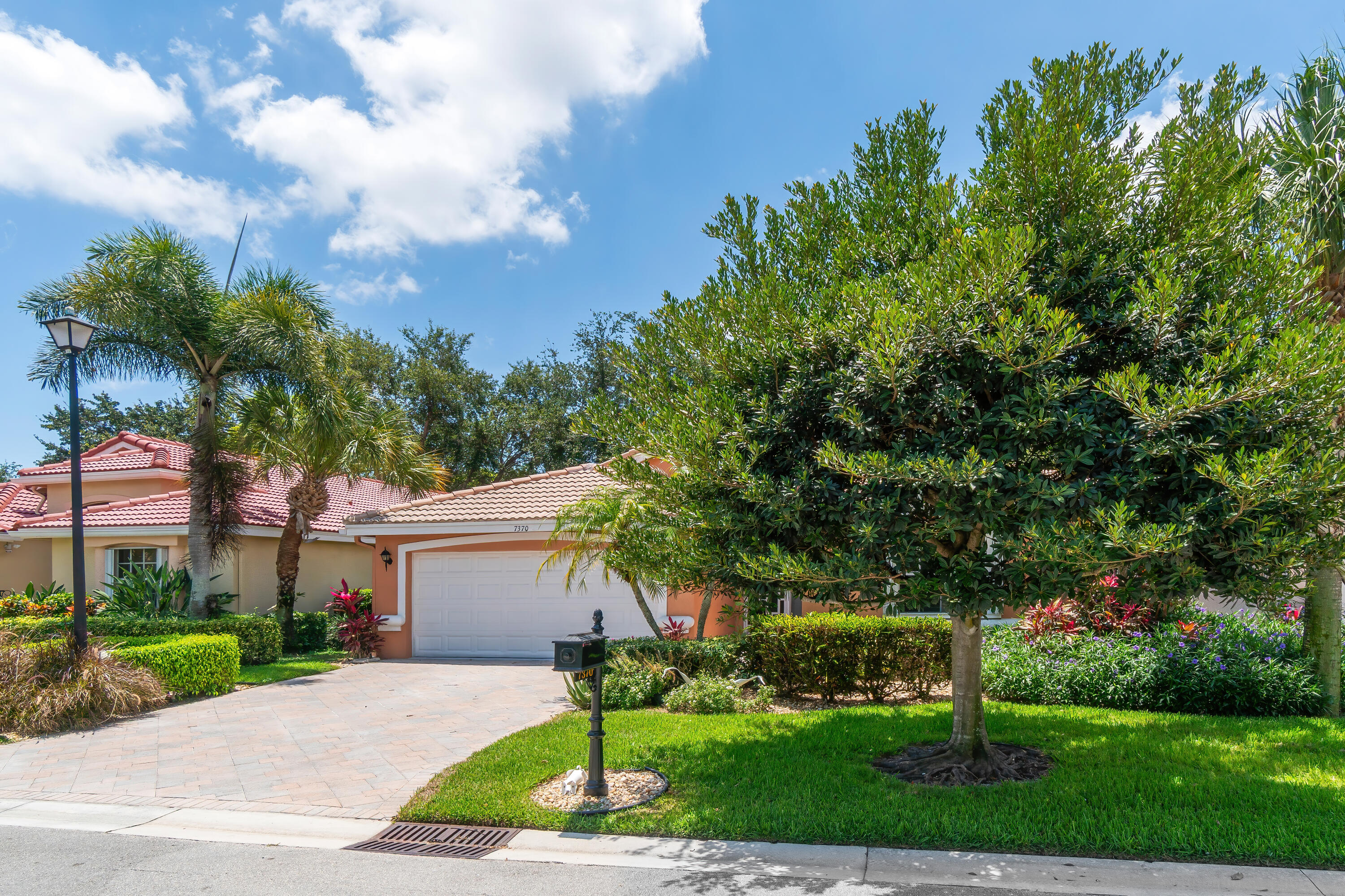 7370 Modena Drive Boynton Beach, FL 33437 - Photo 1 of 37 a front view of a house with garden