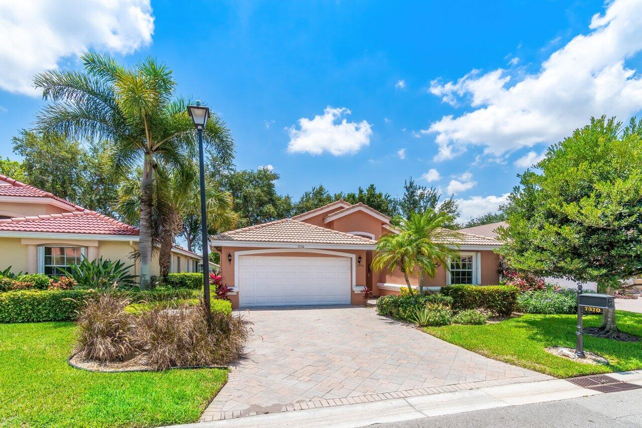 7370 Modena Drive Boynton Beach, FL 33437 - Photo 36 of 37 a front view of a house with a garden and yard