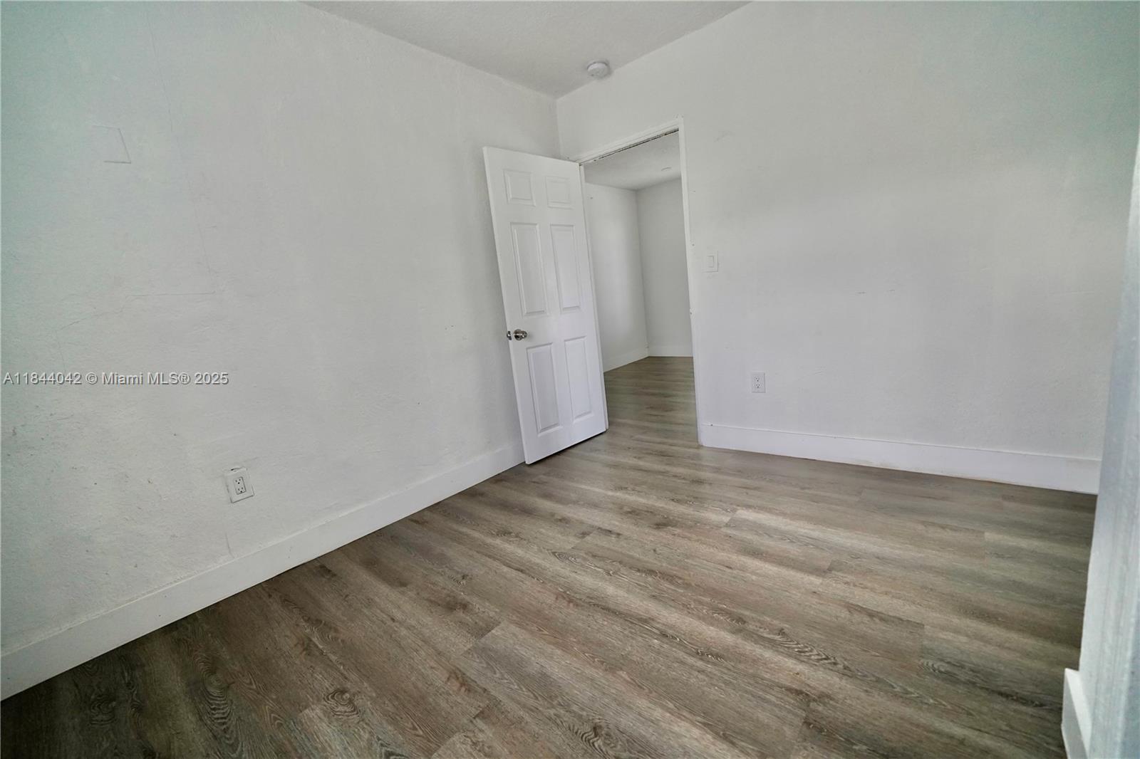 3376 Northwest 49th Street, Unit B Miami, FL 33142 - Photo 12 of 14 a view of an empty room with wooden floor