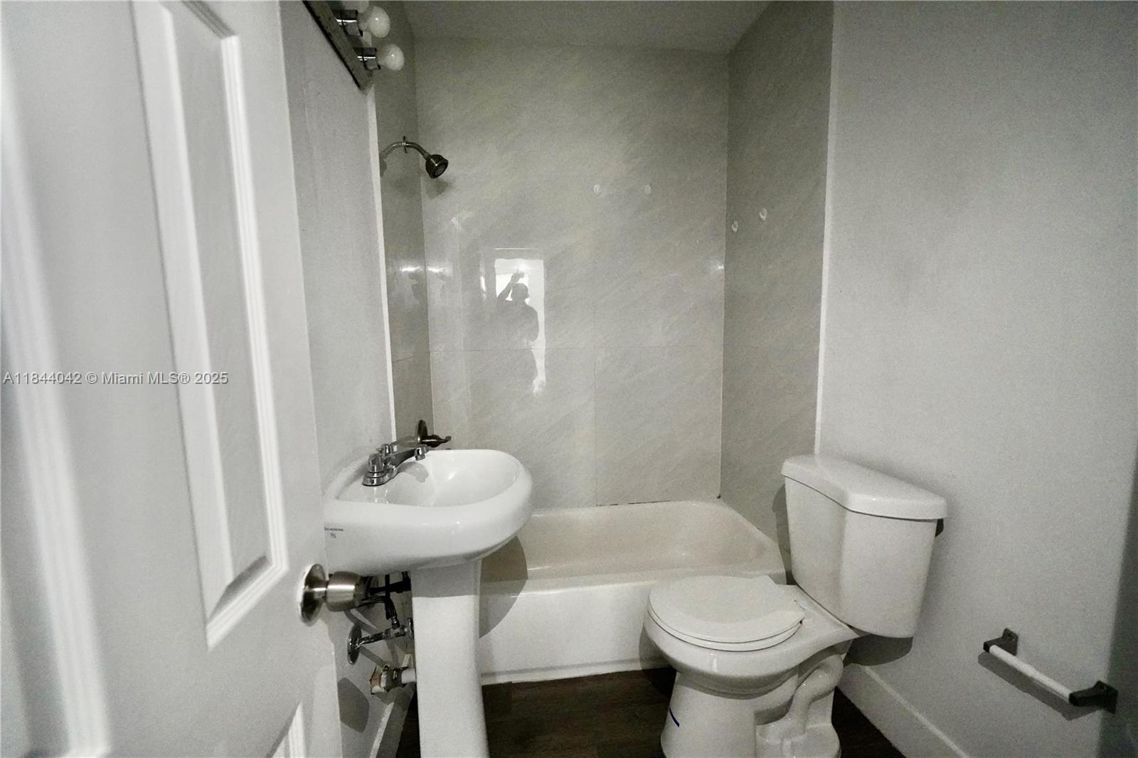 3376 Northwest 49th Street, Unit B Miami, FL 33142 - Photo 13 of 14 a bathroom with a toilet sink and mirror