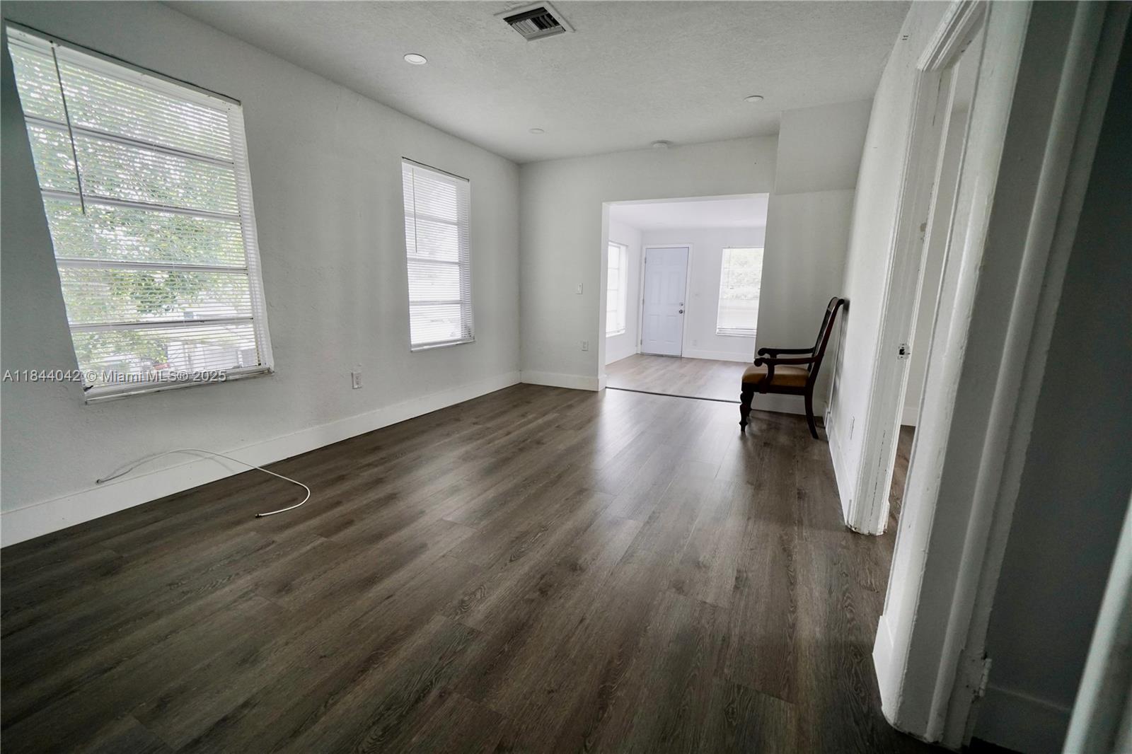 3376 Northwest 49th Street, Unit B Miami, FL 33142 - Photo 5 of 14 a view of empty room with wooden floor and fan