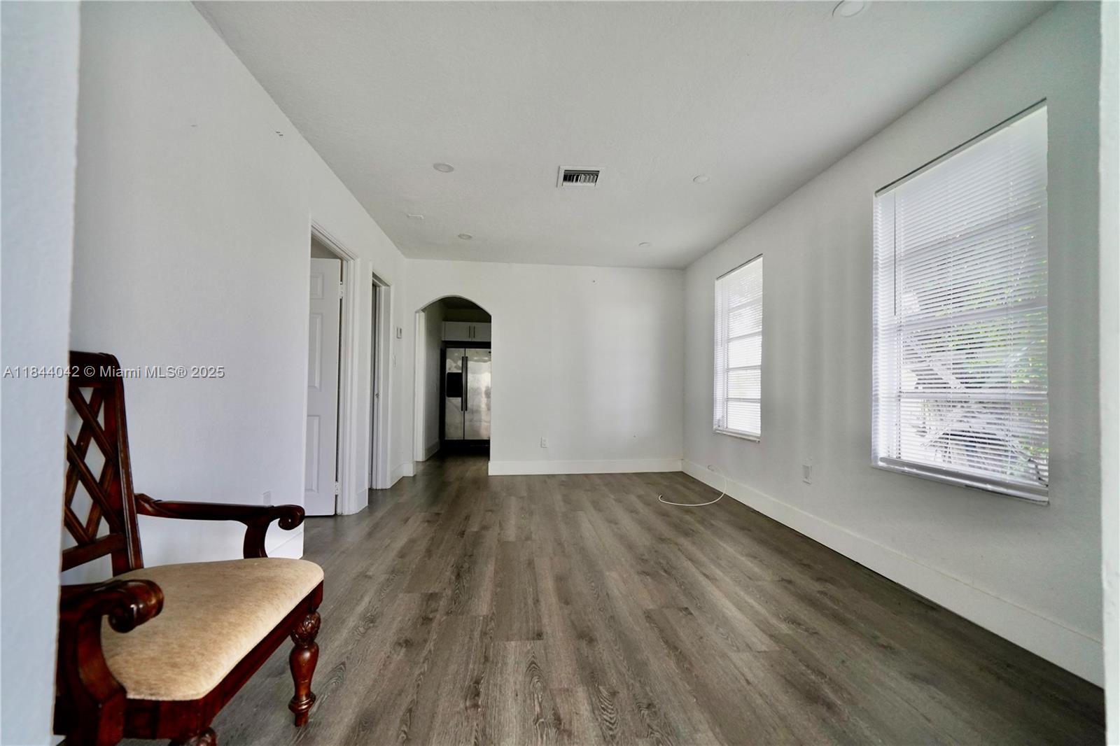 3376 Northwest 49th Street, Unit B Miami, FL 33142 - Photo 6 of 14 a view of a room with wooden floor chandeliers and a window