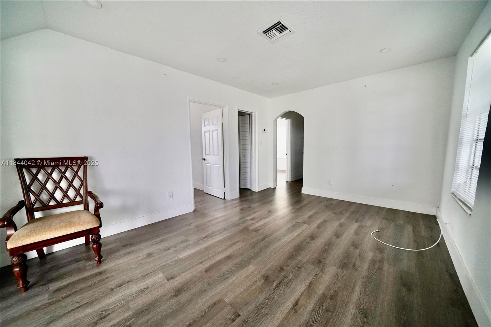 3376 Northwest 49th Street, Unit B Miami, FL 33142 - Photo 7 of 14 a view of a room with wooden floor and furniture