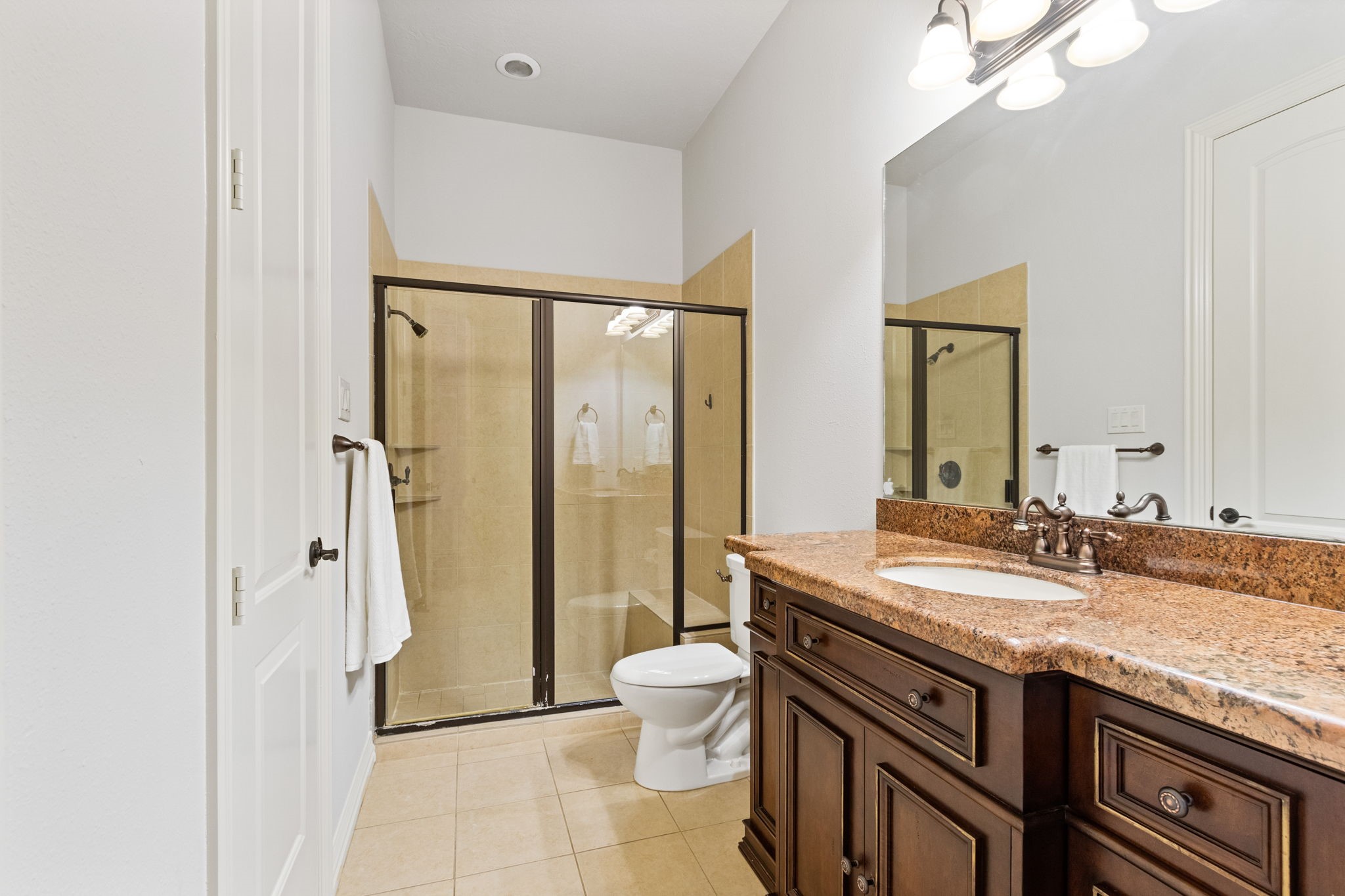 28007 Hickory Court Magnolia, TX 77355 - Photo 33 of 49 a bathroom with a granite countertop sink a toilet a mirror and shower